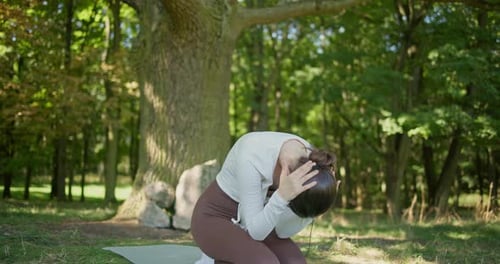 Young Beautiful Athletic Woman in Sportswear Doing Stretching and Warming Up in the Park Near a Tree