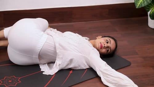 Vidéo d'une femme exécutant Jathara Parivartanasana — Abdominal Twist Pose