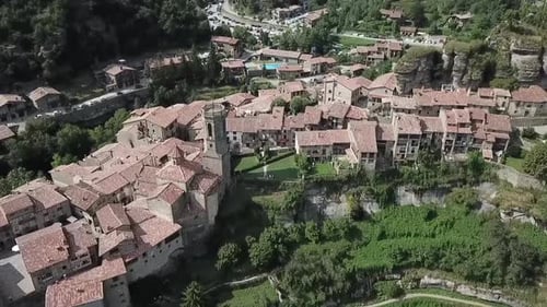 Aerial video of the town of Rofit and a tower among trees in the city, Spain