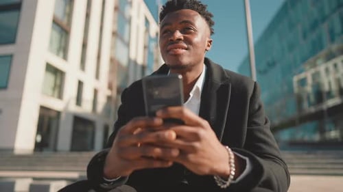 Young Adult Male Person Surfing Internet By Modern Smartphone on City Street Portrait of Cheerful