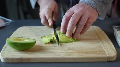 Slicing Fresh Avocado on Wooden Cutting Board
