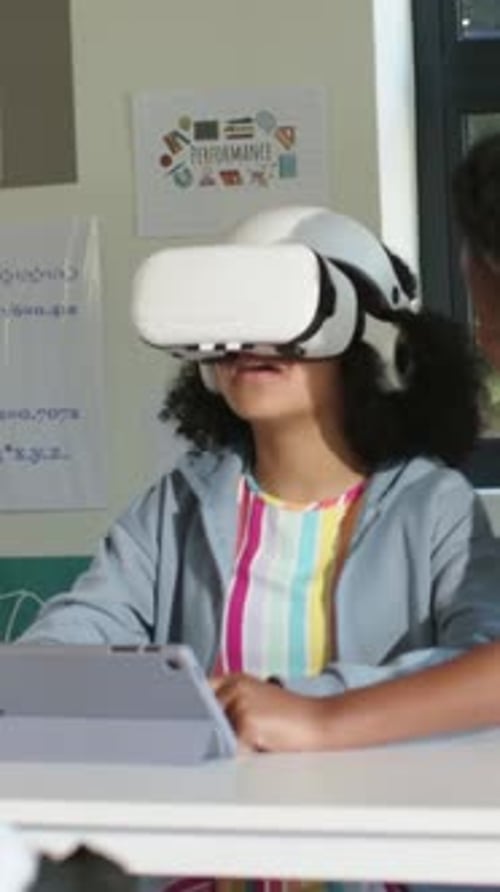 Student touching tablet wearing VR headset, learning math with animated charts appearing on tablet