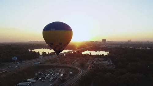 Hot Air Balloon Soaring Above City at Sunset Showcasing Stunning Aerial View