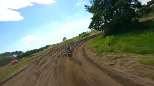 Motocross Rider Speeds Along Dirt Track in Countryside