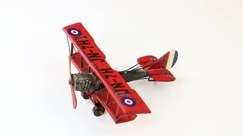 Vintage Red Biplane Miniature Model on White Background