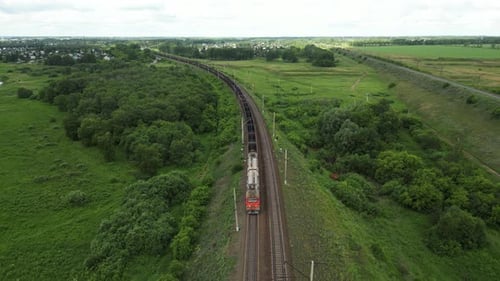 Aerial View of Freight Train Traversing Lush Green Landscape Showcasing Scenic Rail Journey Under
