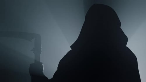 Death with Scythe Indoors. Grim Reaper Standing in Darkness. Scary Scytheman in Floodlight...