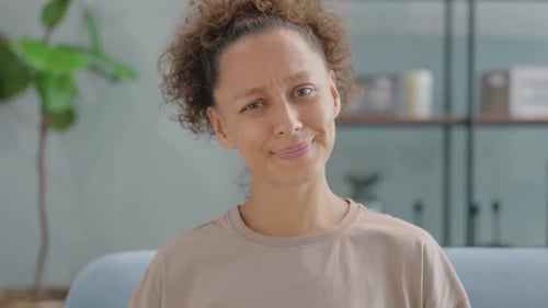 Woman With Curly Hair Looking at Camera Indoors