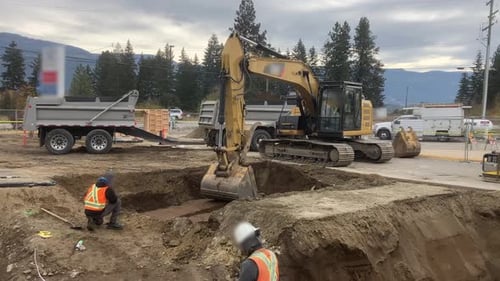 Excavator Loads Soil in Urban Construction Site