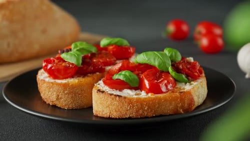 Bruschetta au ricotto et aux tomates cerises, basilic, ail sur fond noir. Gros plan