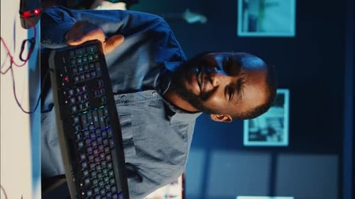 Man Holding Computer Accessories in Blue Lit Room