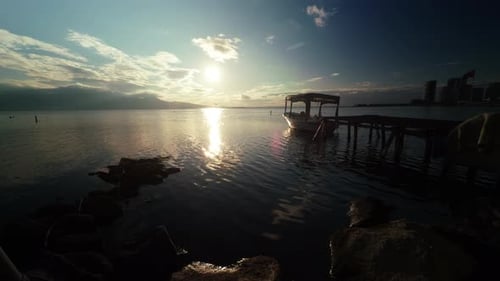 Warm Sunset Reflections Over Fishing Boats In A Quiet Seaside Harbor