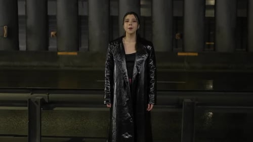 Woman Sings in Fashionable Coat at Night