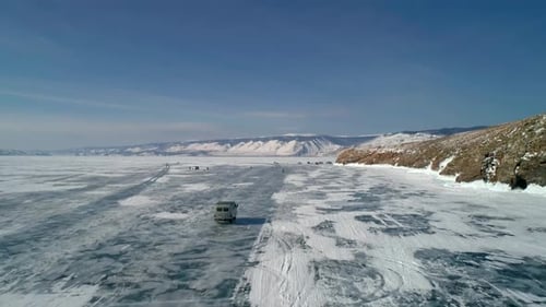 Aerial View on Tourist Cars Driving on Cracked Ice of Baikal to the Famous Tourist Spot Tourists
