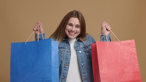 Happy Woman Showing Shopping Bags in Studio