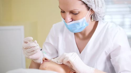 Woman getting cosmetic injection procedure from dermatologist
