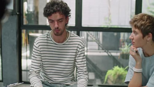 Young Adults Discussing Project in Office Setting