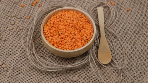 Orange Lentils in Bowl with Wooden Spoon