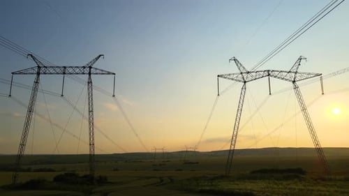 Power Lines Crossing Rural Landscape at Sunset
