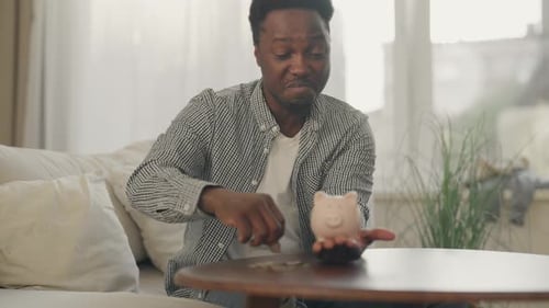 Economy and Finance Young Black Man Saving Money in Piggy Bank Closeup View African American Student