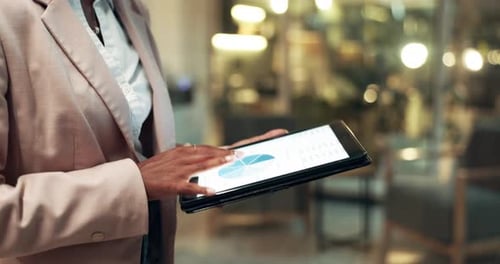 Businesswoman Analyzing Data on Tablet in Office