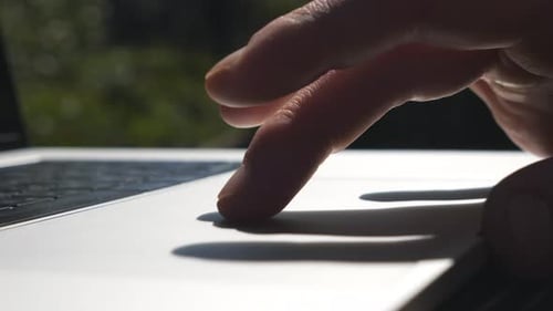 Male Fingers Touching and Sliding on Touchpad of Laptop