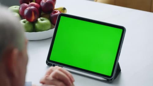 Senior Man Use Video Call On Tablet With Green Screen Chroma Key Technology For Montage