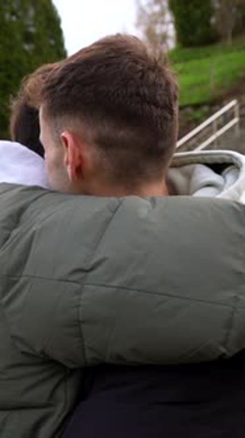 Young caucasian gay couple sharing intimate moments in public park