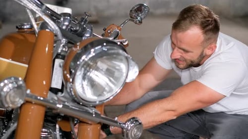 A Male Mechanic Repairs His Motorcycle in a Garage Retro Motorcycle Service