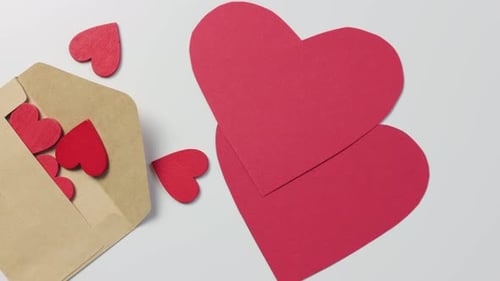 Red Paper Hearts and Envelope on White Background