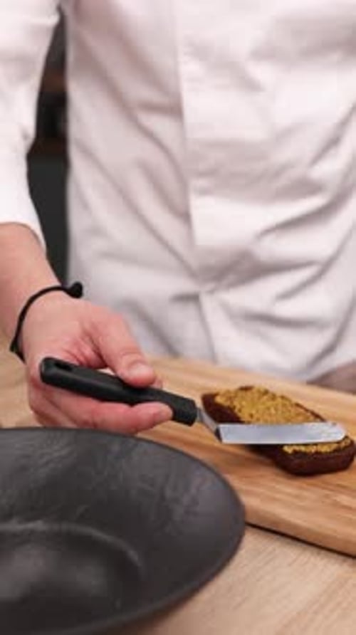 The chef is preparing a sandwich in the kitchen. Close-up