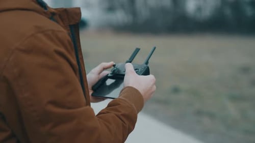 Man Operating Drone Controller in Outdoor Setting