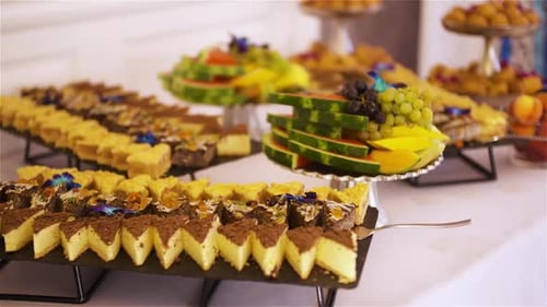 Dessert Buffet with Cakes Pastries and Fresh Fruit on Display Stands