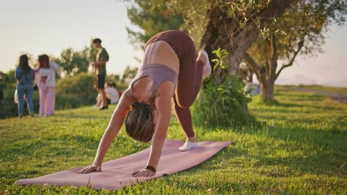 Woman Practicing Yoga Outdoors on Grassy Ground