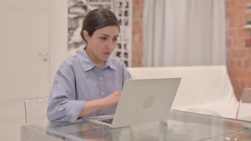 Junge Inderin hustet bei der Arbeit am Laptop