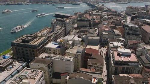 Une vue en angle élevé des bâtiments à plusieurs étages d'un arrondissement urbain, inclinée vers le haut, révèle la circulation des bateaux sur l'eau