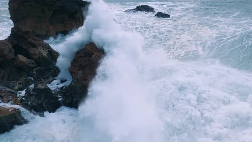 Dramatic Ocean Waves Crashing Powerfully Against Jagged Coastal Rocks