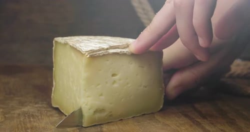 Close-up of Cheese Being Cut with Knife