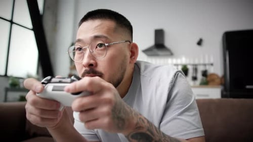 Asian Man Playing Video Game Holding Joystick Close Up 30s Man Playing Games with Controller Sitting