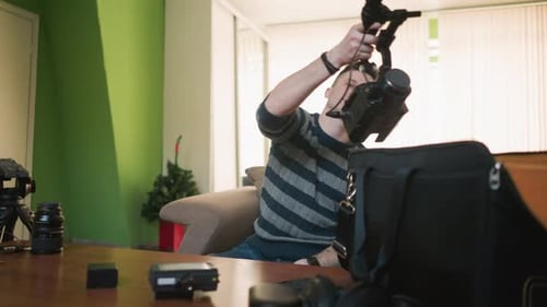 Man Assembles Camera Gear in Bright Room