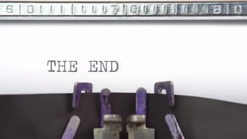 The End phrase closeup being typing and centered on a sheet of paper on old vintage typewriter