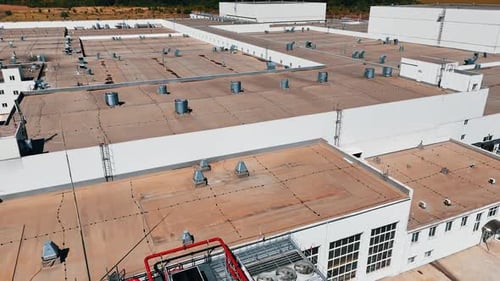 Survol du toit de l'usine. Perspective aérienne sur de multiples tuyaux sortant du sommet de la plante.