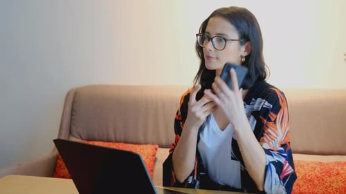 Woman Working with Laptop and Mobile Phone at Home