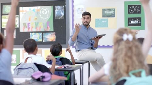 Young Asian man teaches in a vibrant classroom at school