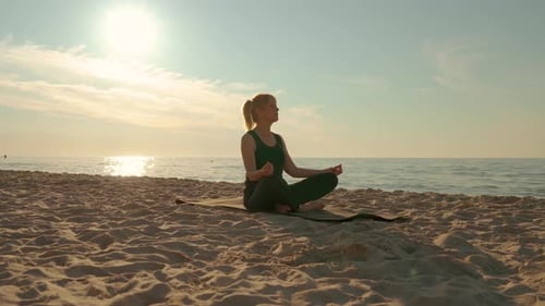 Young Woman Doing Balance Exercise and Stretching Sports Yoga Outdoors at Sunset Beach