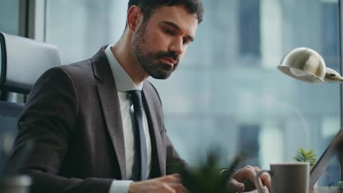 Serious Office Employee Typing Laptop Sitting at Desk Drinking Coffee Close Up