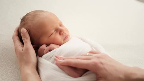 Sleeping Newborn Cared For by Loving Parent