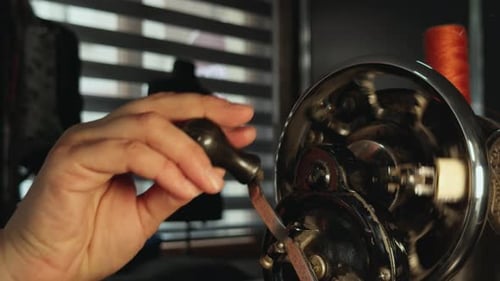 Close-Up of Adult Hand Operating Vintage Sewing Machine