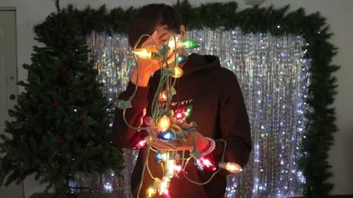 Happy hispanic man preparing for Christmas season with light decorations