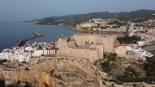 The Castle overlooks the village, harbor, and Mediterranean Sea from the crag on the cliffs - aerial
